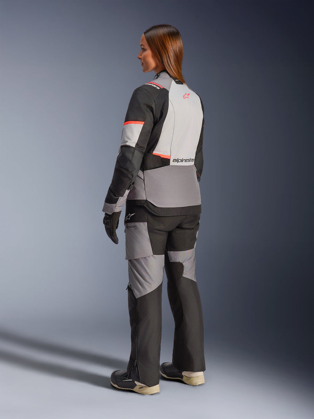 Alpinestars Stella Andes V4 Drystar, casaco de moto para aventura e touring para mulher, cinzento e preto com detalhes coral, impermeável, vista traseira.