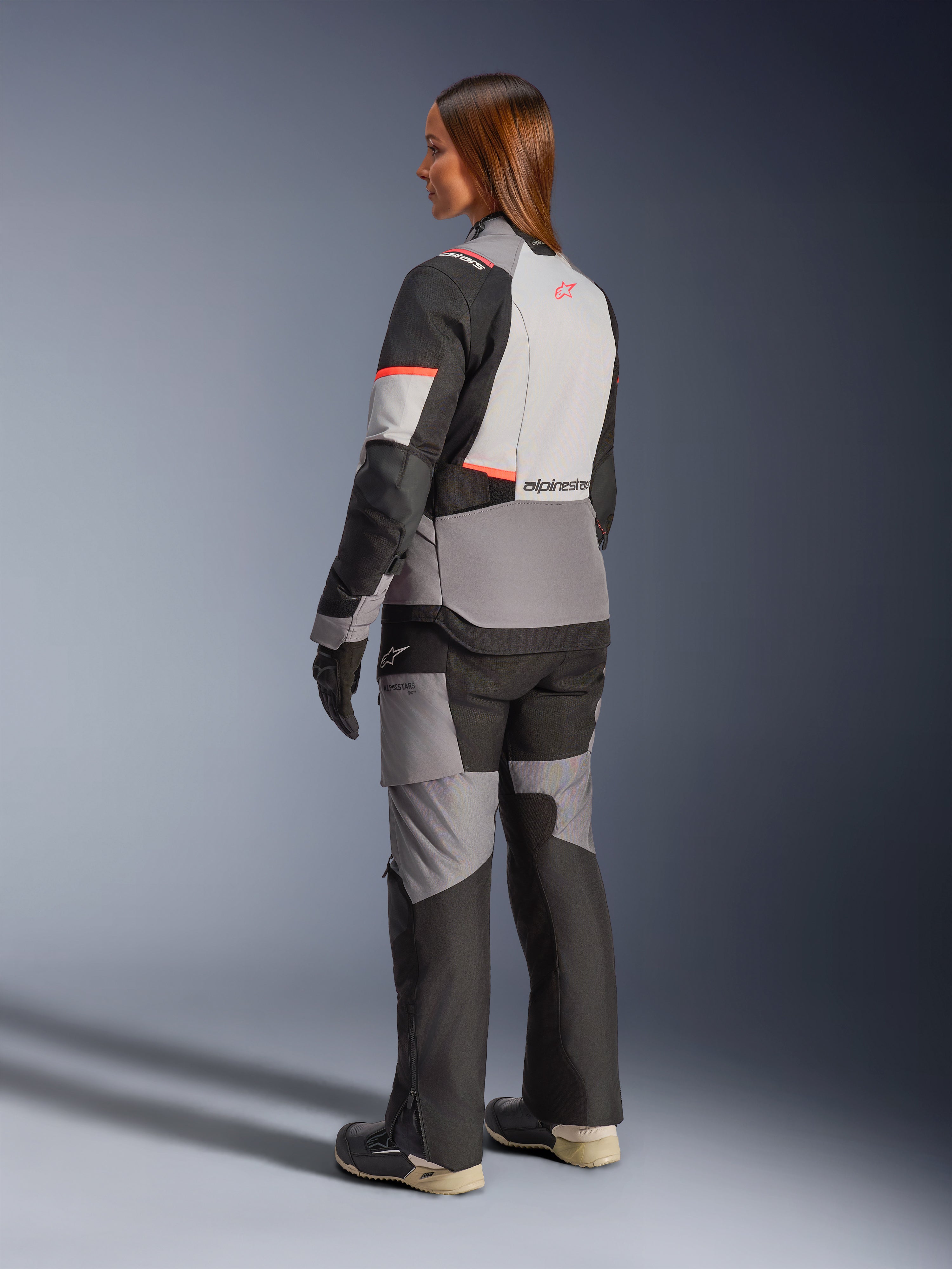 Alpinestars Stella Andes V4 Drystar, casaco de moto para aventura e touring para mulher, cinzento e preto com detalhes coral, impermeável, vista traseira.