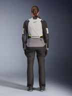 Mulher motociclista vista de costas a usar o Casaco Alpinestars Stella Andes V4 Drystar®, em Ice Gray, Cinzento Escuro e Preto com detalhes em Amarelo Fluo, com um grande bolso de armazenamento traseiro e logótipo Alpinestars, combinada com calças de aventura pretas a condizer, equipamento de touring para motociclismo para todas as condições climatéricas