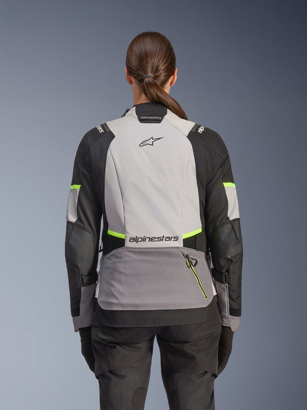 Alpinestars Stella Andes V4 Drystar® Jacket, casaco de motociclismo de aventura para mulher, vista traseira, Cinzento Gelo, Cinzento Escuro e Preto com detalhes em Amarelo Fluo, com logótipos Alpinestars na parte superior e inferior das costas, construção têxtil durável para turismo em qualquer clima