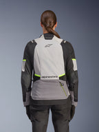 Alpinestars Stella Andes V4 Drystar® Jacket, casaco de motociclismo de aventura para mulher, vista traseira, Cinzento Gelo, Cinzento Escuro e Preto com detalhes em Amarelo Fluo, com logótipos Alpinestars na parte superior e inferior das costas, construção têxtil durável para turismo em qualquer clima