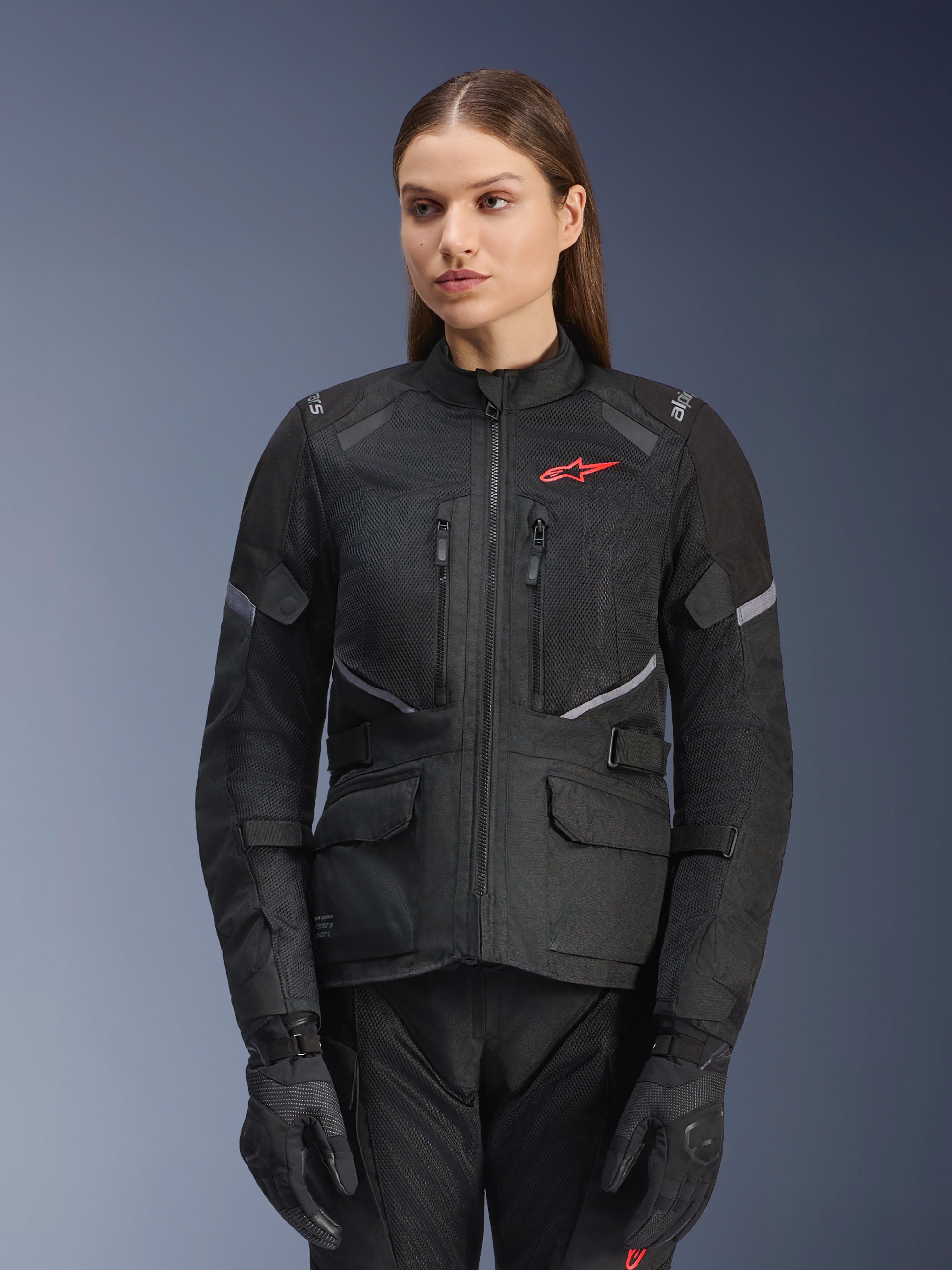 Alpinestars Stella Andes Air Drystar Jacket, casaco de motociclismo de turismo para mulher, preto com detalhes cinzentos e um pequeno logótipo vermelho, com painéis de ventilação em malha, gola alta e múltiplos bolsos utilitários, usado com luvas e calças de condução a condizer