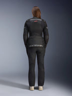 Mulher a usar o Casaco Alpinestars Stella Andes Air Drystar® e calças a condizer, preto, vista traseira exibindo a grande marca Alpinestars a cinzento na bolsa lombar, logótipo pequeno de estrela vermelha na parte superior das costas, painéis de ventilação em malha e detalhes refletores para adventure touring