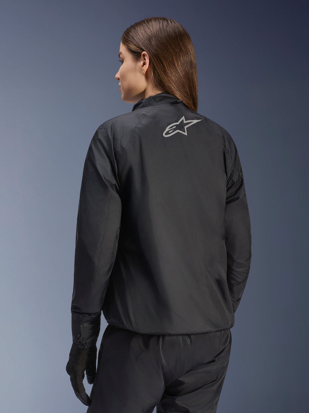 Casaco Alpinestars Stella Andes Air Drystar®, casaco de motociclismo para mulher, preto, vista traseira mostrando o logótipo da estrela prateada, combinado com calças e luvas pretas, equipamento de touring leve e impermeável