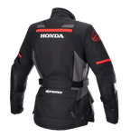 Casaco Alpinestars Stella Honda Andes V3 Drystar® para Mulher, casaco de motociclismo de aventura, preto, cinzento e vermelho vivo, vista traseira com logótipo HONDA branco em destaque e grafismos Alpinestars em vermelho, construção têxtil impermeável com cintura ajustável e bolsos utilitários