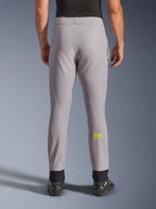Alpinestars Aeroshell Pants, calças de motociclismo, cinzento médio e amarelo néon, vista traseira mostrando o logótipo Astars amarelo na barriga da perna, punhos elásticos pretos nos tornozelos, design têxtil softshell moderno para condução em estrada e casual