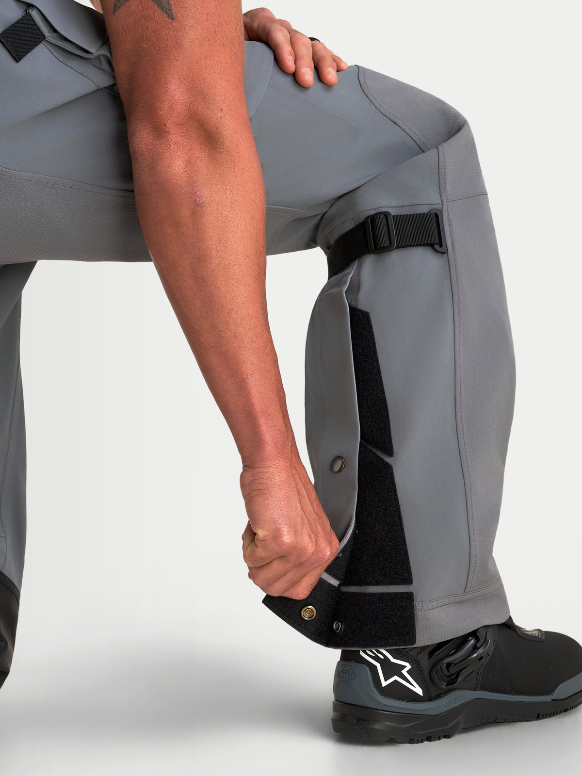 Alpinestars Maxdura Drystar XF Laminated calças de moto adventure para homem em cinzento escuro e preto, com construção ajustável na parte inferior da perna e ajuste over-the-boot com botas de moto pretas