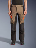 Alpinestars Andes V4 Drystar® Pants, calças de motociclismo de aventura e turismo em castanho e preto, com fechos laranja brilhante nas coxas, painéis pretos reforçados nos joelhos e construção têxtil durável para todas as condições climatéricas.
