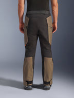 Alpinestars Cusco Drystar® Pants, calças de motociclismo de aventura, Walnut Black, vista traseira no modelo, construção têxtil durável com painéis em blocos de cor, bainha ajustável e detalhe de fecho de correr na cintura para touring e condução de aventura