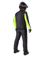 Rider from the rear wearing Alpinestars Bogotá Pro Drystar® 3 Seasons Pants in Black, paired with a black jacket featuring fluorescent yellow sleeves, black adventure helmet, and boots, complete adventure touring gear