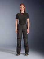 Calças Alpinestars Stella Andes V4 Drystar®, calças de motociclismo de aventura e touring para mulher, pretas, apresentadas numa modelo com uma t-shirt Alpinestars preta, com um design têxtil técnico, bolsos cargo e painéis reforçados nos joelhos.