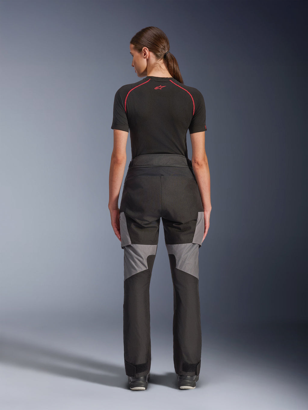 Alpinestars Stella Andes V4 Drystar® Pants, calças de motociclismo para mulher, pretas e cinzento escuro, vista traseira mostrando reforços ripstop cinzentos e design ergonómico, usadas com uma camada base técnica preta, equipamento de condução adventure touring