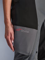 Alpinestars Stella Andes V4 Drystar® Pants, calças de aventura-touring para mulher, pretas e cinzento escuro, pormenor da zona da coxa mostrando o logótipo Drystar e a estrela Alpinestars vermelha em painéis têxteis reforçados