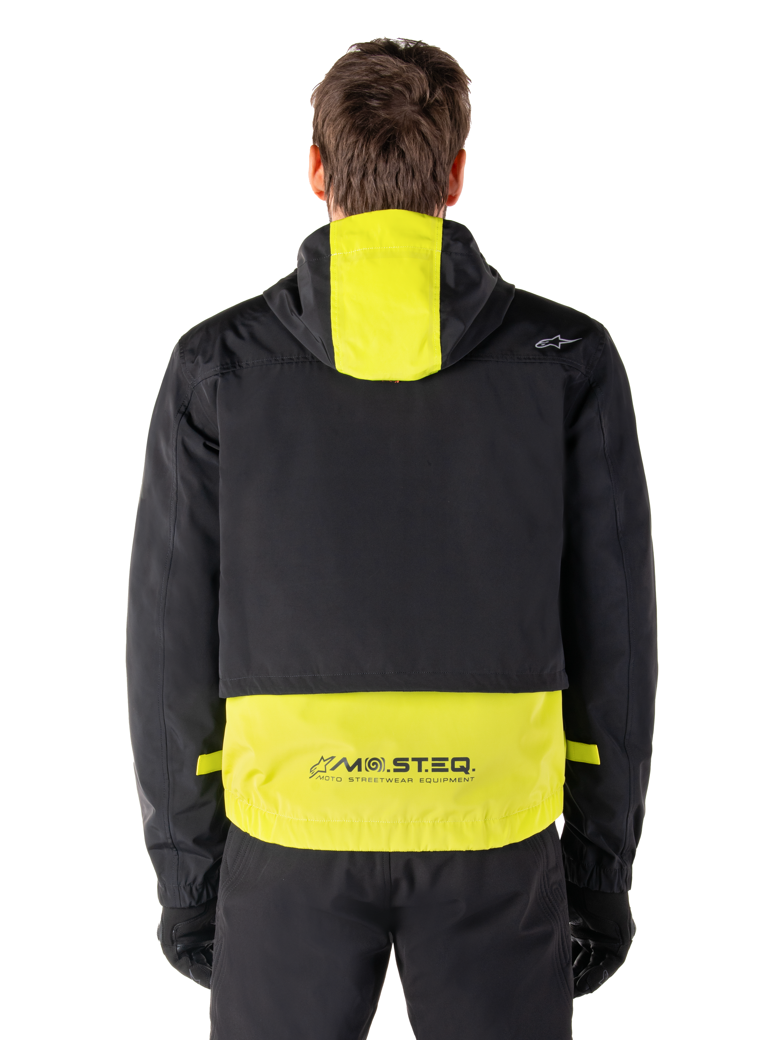 Alpinestars Mootant Waterproof Parka, Motorcycle Jacket, Lime Punch and Black, rear view showing hooded design and reflective MO.ST.EQ. branding on the lower back, worn with black riding pants and gloves.