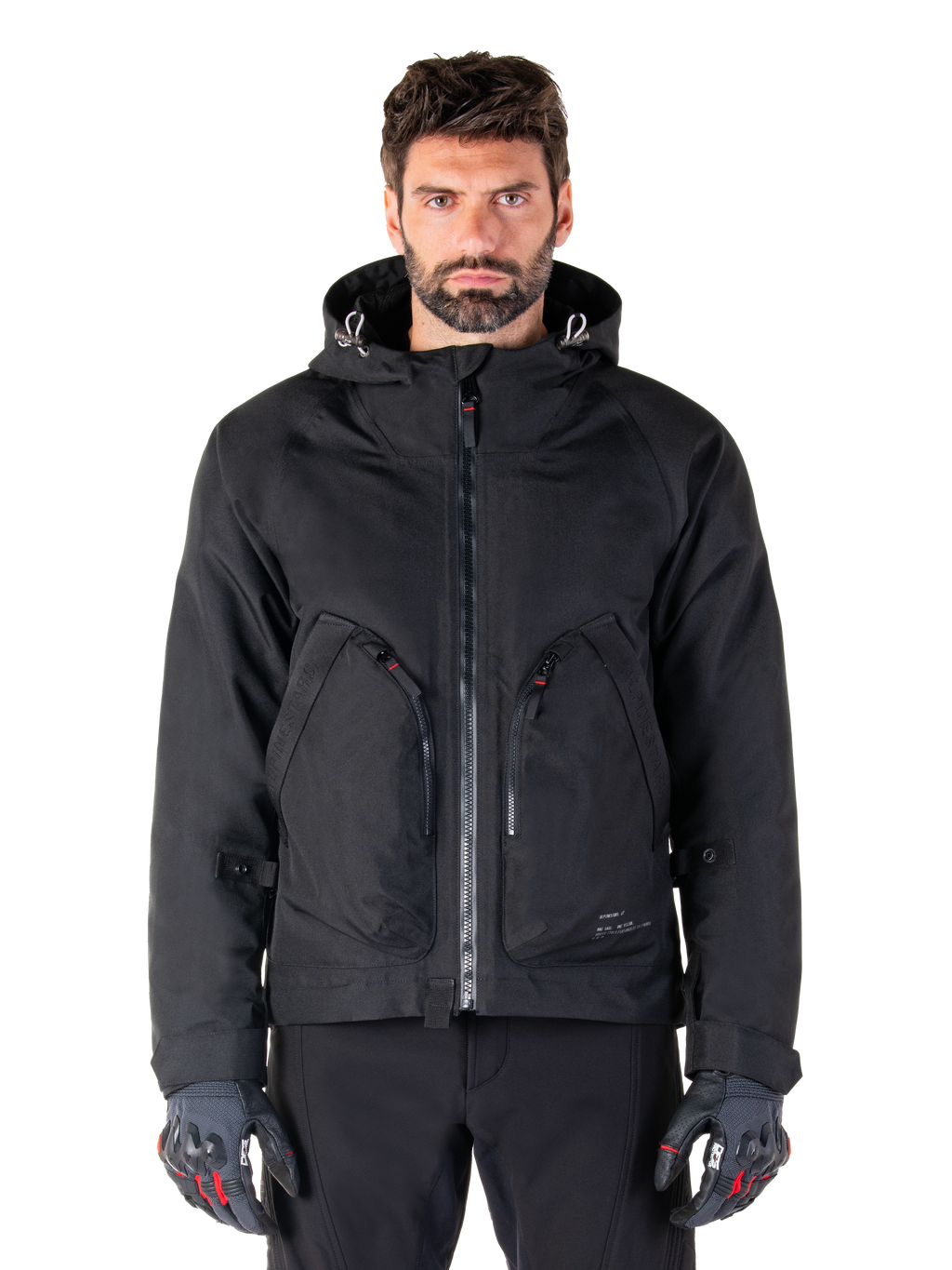 Alpinestars Morush Waterproof Parka, Black Motorcycle Jacket, Hooded Design with Front Zipper and Two Large Zippered Pockets, Worn with Black and Red Gloves, Urban Riding Gear