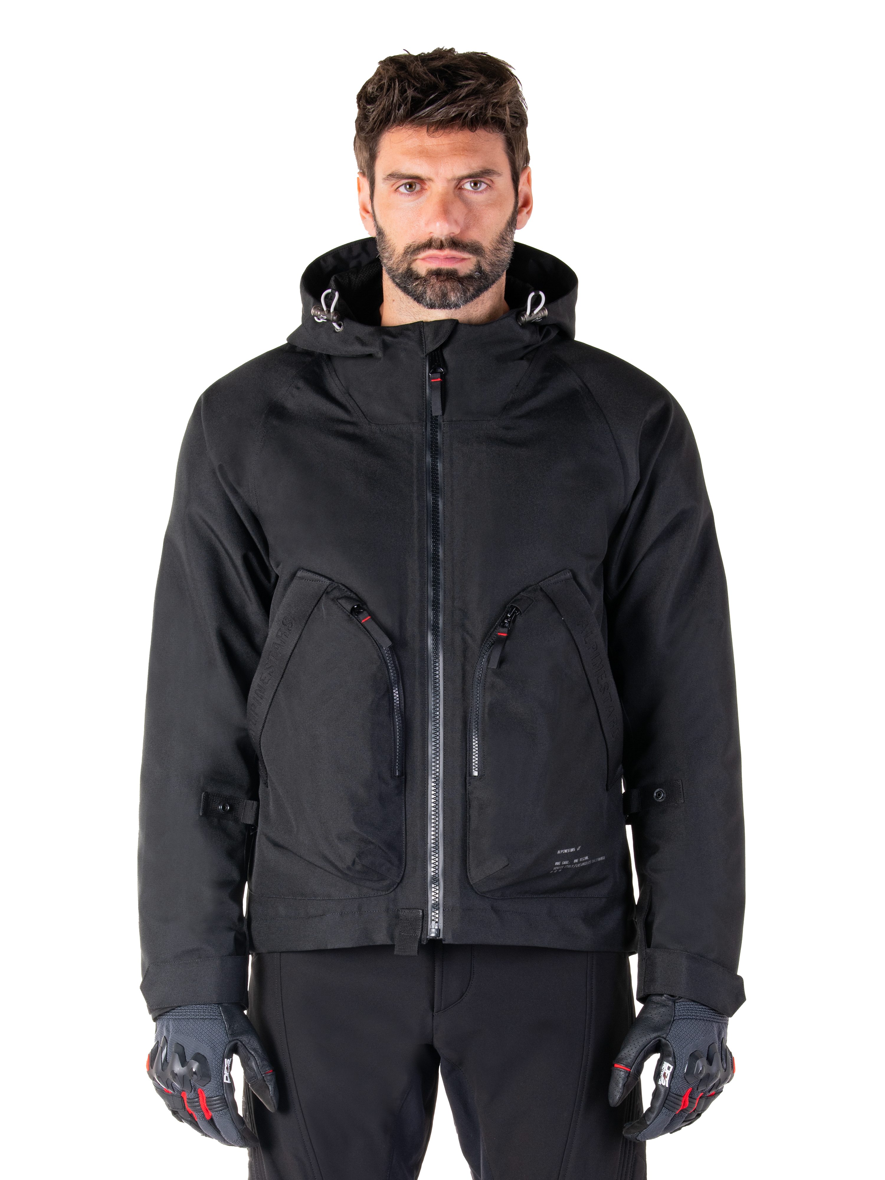 Alpinestars Morush Waterproof Parka, Black Motorcycle Jacket, Hooded Design with Front Zipper and Two Large Zippered Pockets, Worn with Black and Red Gloves, Urban Riding Gear