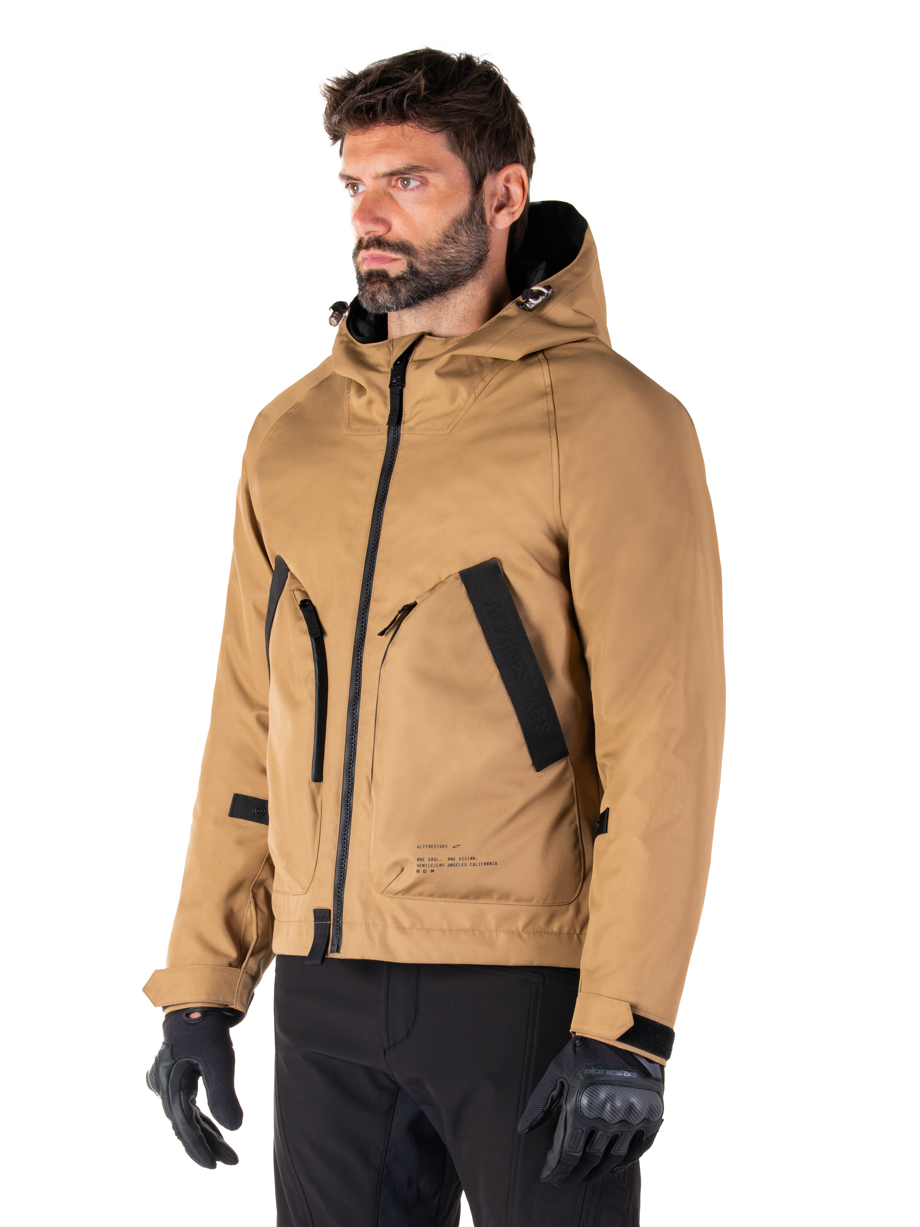 Alpinestars Morush Waterproof Parka, Utility Brown, male model wearing parka with black riding gloves and black pants, minimalist streetwear-inspired design featuring a stormproof hood and large front pockets, waterproof motorcycle apparel