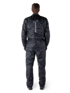 Alpinestars Hurricane Rain V2 Suit, Black One-Piece Waterproof Motorcycle Suit, back view showing large vertical Alpinestars wordmark and logo, lightweight crinkled fabric with elasticated waist and cuffs, designed for wet weather riding protection.