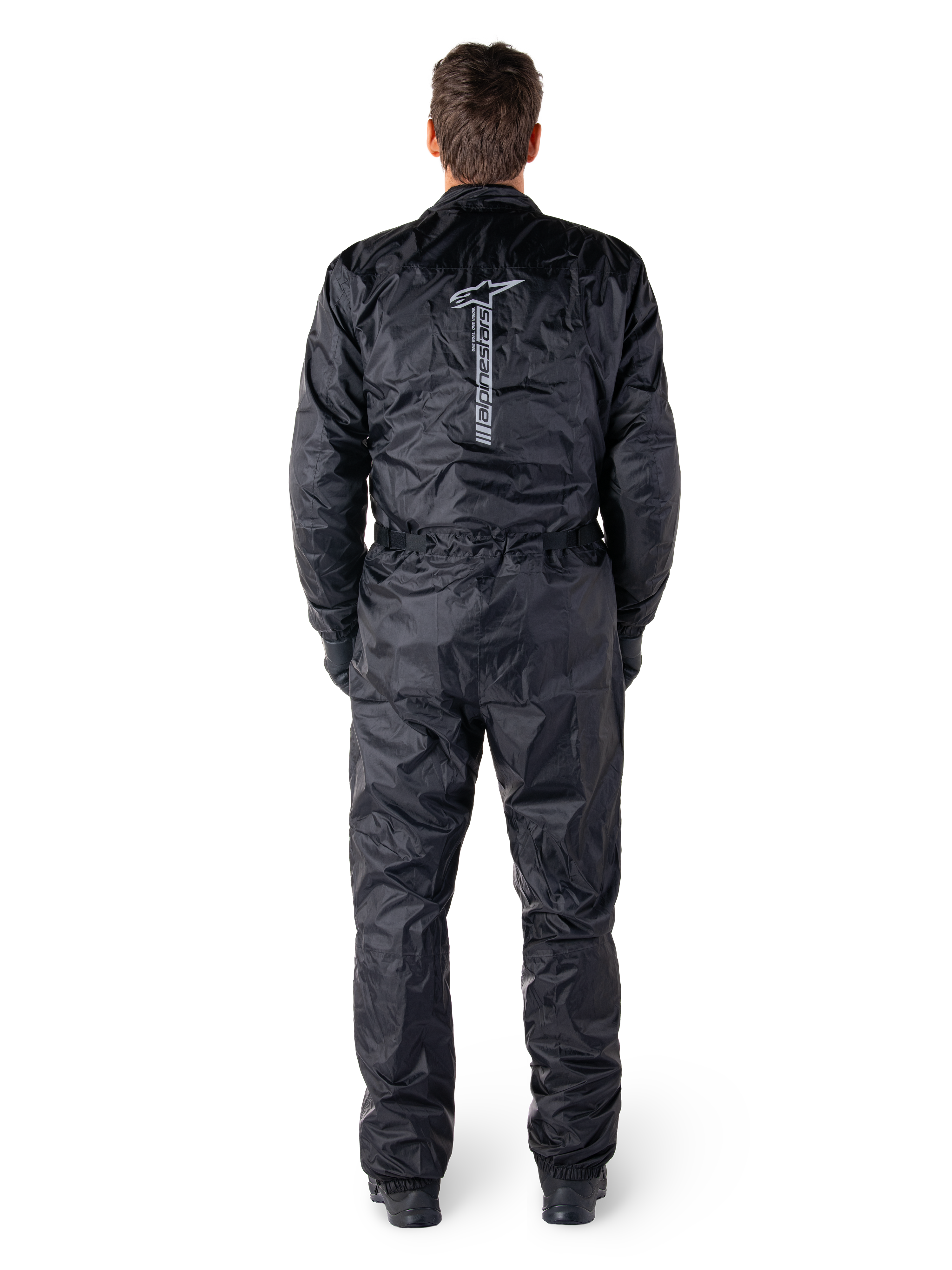 Alpinestars Hurricane Rain V2 Suit, Black One-Piece Waterproof Motorcycle Suit, back view showing large vertical Alpinestars wordmark and logo, lightweight crinkled fabric with elasticated waist and cuffs, designed for wet weather riding protection.