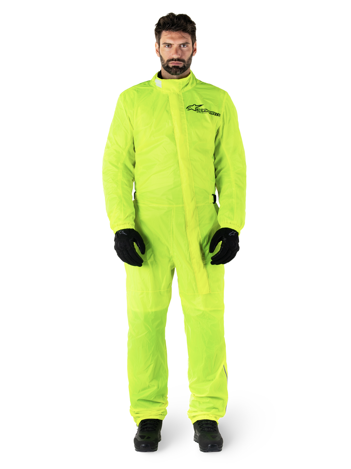Alpinestars Hurricane Rain V2 Suit, fato de chuva para motociclismo, amarelo néon, modelo masculino com proteção de corpo inteiro, luvas e botas pretas, gola alta com aba protetora frontal, logótipo refletor no peito, equipamento impermeável de alta visibilidade