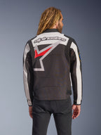Casaco Alpinestars Axton, casaco de motociclismo, preto, off-white e vermelho brilhante, vista traseira com um grande logótipo de estrela envolvente e marca nominativa, design de inspiração vintage com painéis de acordeão nos ombros e ajustadores na cintura