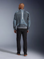 Alpinestars Flight Air Jacket em Storm Gray, vista traseira de modelo masculino a usar casaco de motociclismo de estilo urbano com painéis de malha 3D e logótipo Alpinestars vertical, combinado com calças pretas para um visual urbano moderno