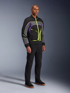 Casaco Alpinestars Unite, casaco de motociclismo urbano, Black Asphalt Violet com detalhes em amarelo néon, vestido por um modelo com calças pretas e sapatilhas, estilo streetwear contemporâneo para condução urbana