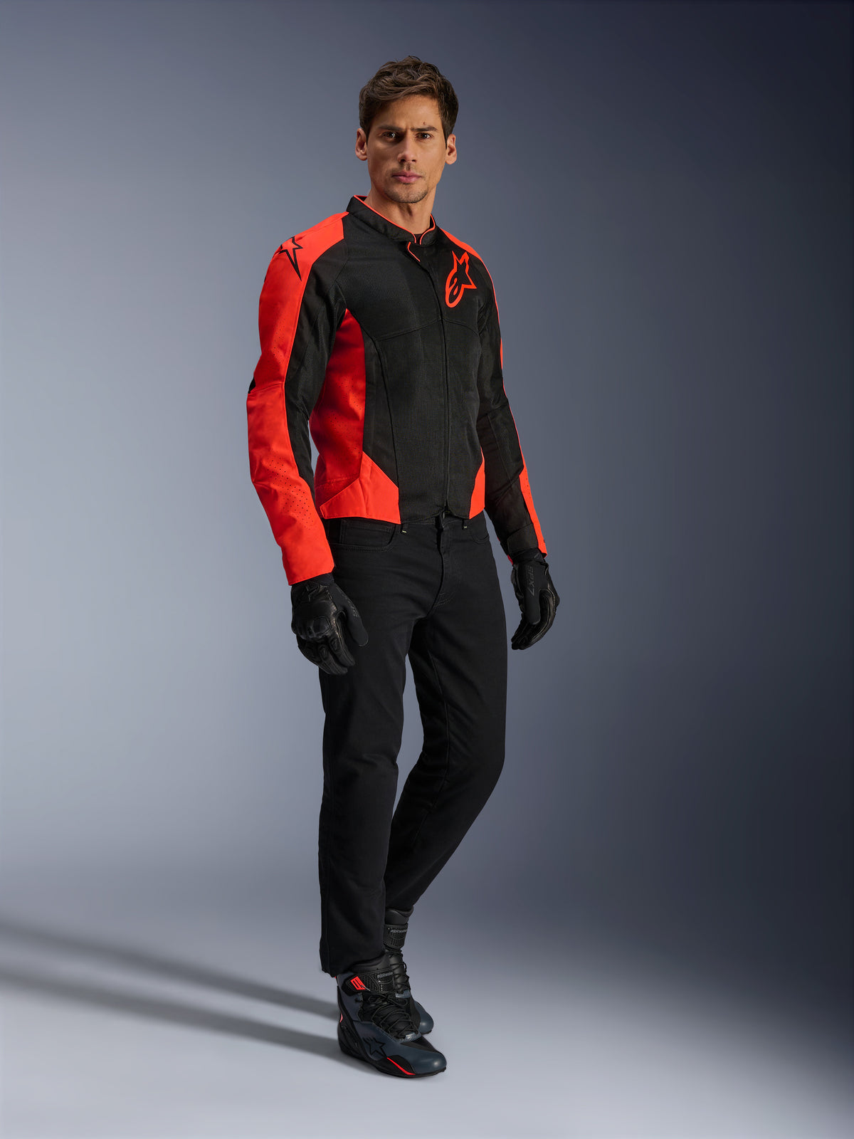 Alpinestars Viper Air V4 Jacket, casaco de motociclismo, vermelho fluo e preto, usado por um modelo com calças de ganga de motociclismo pretas, luvas pretas e sapatos de motociclismo, design em malha têxtil com painéis vermelhos vibrantes e logótipo de estrela, equipamento desportivo para condução em estrada