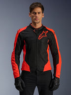 Alpinestars Viper Air V4 Jacket, casaco de motociclismo desportivo, vermelho fluo e preto, usado por modelo com luvas pretas, painéis em malha tecnológica para ventilação, design desportivo com logótipo de estrela da Alpinestars no peito