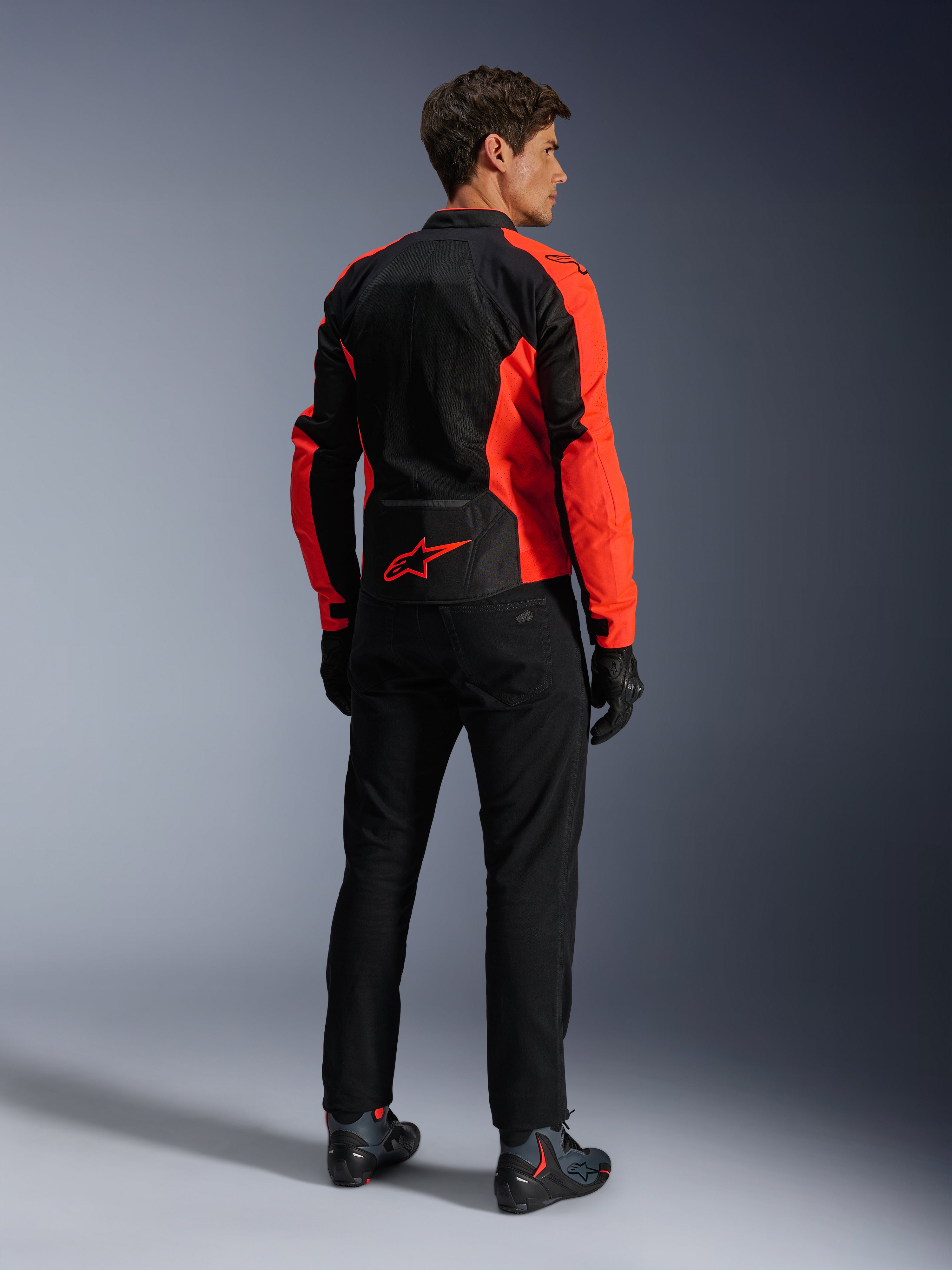Casaco Alpinestars Viper Air V4, Vermelho Fluo e Preto, vista traseira no modelo, com painéis de malha tecnológica e um logótipo de estrela vermelha na parte inferior das costas, combinado com calças e luvas de motociclismo pretas para um look completo de condução em estrada.