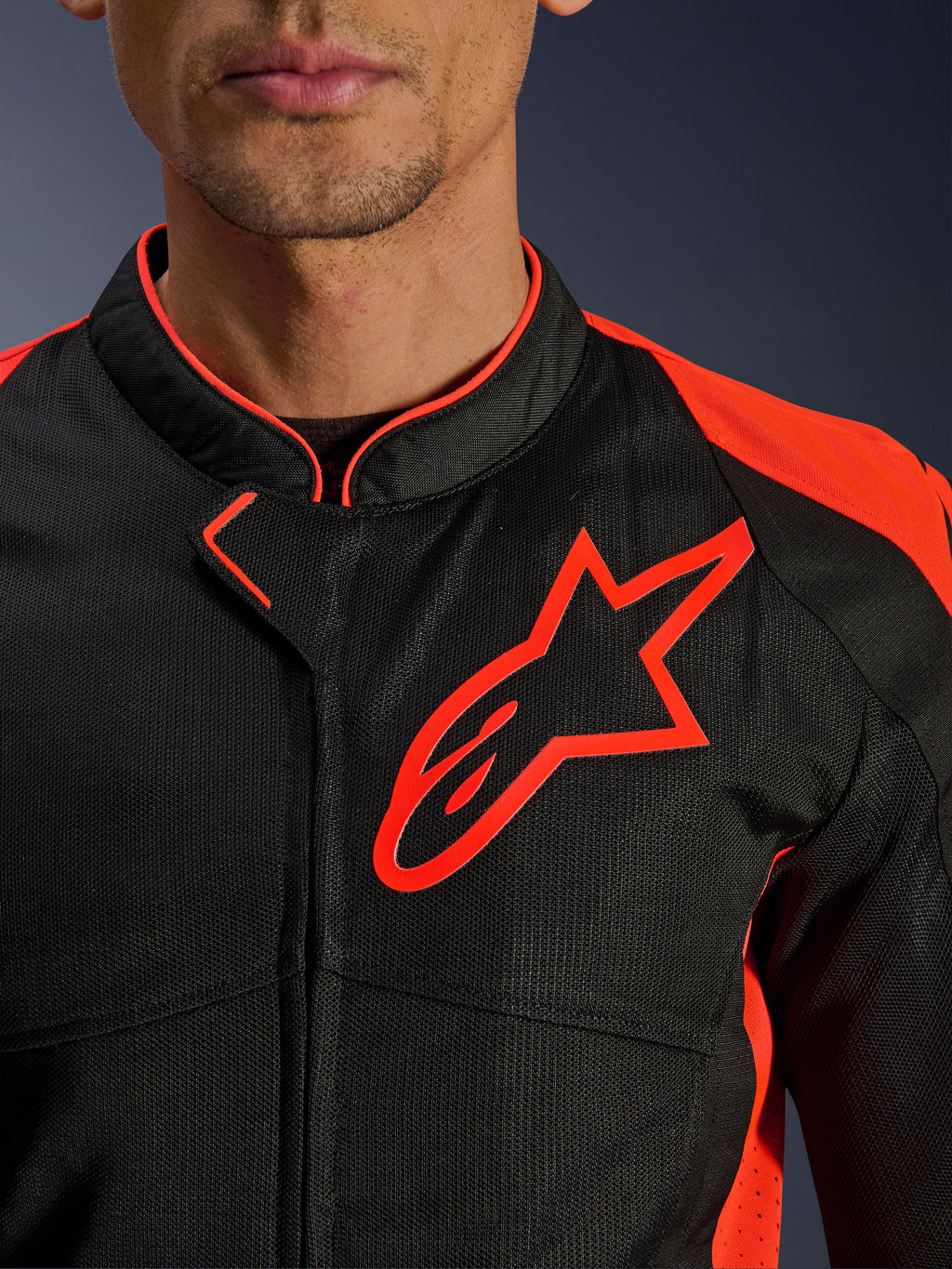 Casaco Alpinestars Viper Air V4 em Red Fluo Black, vista em grande plano do peito e da gola, com construção em malha técnica preta, logótipo Alpinestars vermelho proeminente e pormenores em vermelho vibrante nos ombros.