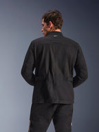 Alpinestars Dice Jacket, casaco de motociclista urbano, preto, vista traseira mostrando ombros pregueados e abas de ajuste na cintura, estética de casaco de campo com pequeno logótipo branco no colarinho, equipamento têxtil de proteção para condução urbana