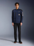 Alpinestars Dice Jacket, Urban Motorcycle Jacket, Dark Blue and Black, worn by a model with black pants and black shoes, modern field jacket design with multiple pockets, vertical chest zipper, and white Alpinestars branding on the sleeves.