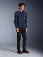 Alpinestars Dice Jacket, Dark Blue and Black, modern field-style motorcycle jacket worn by a model with black pants and black high-top sneakers, featuring multiple utility pockets, vertical Alpinestars branding on the sleeve, and woven patches, urban contemporary riding gear
