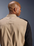 Alpinestars Dice Jacket, casaco de motociclismo urbano, bege e preto, detalhe em grande plano da gola traseira e do ombro, com logótipo bordado, construção robusta em sarja de policotão, estilo workwear pronto para a rua