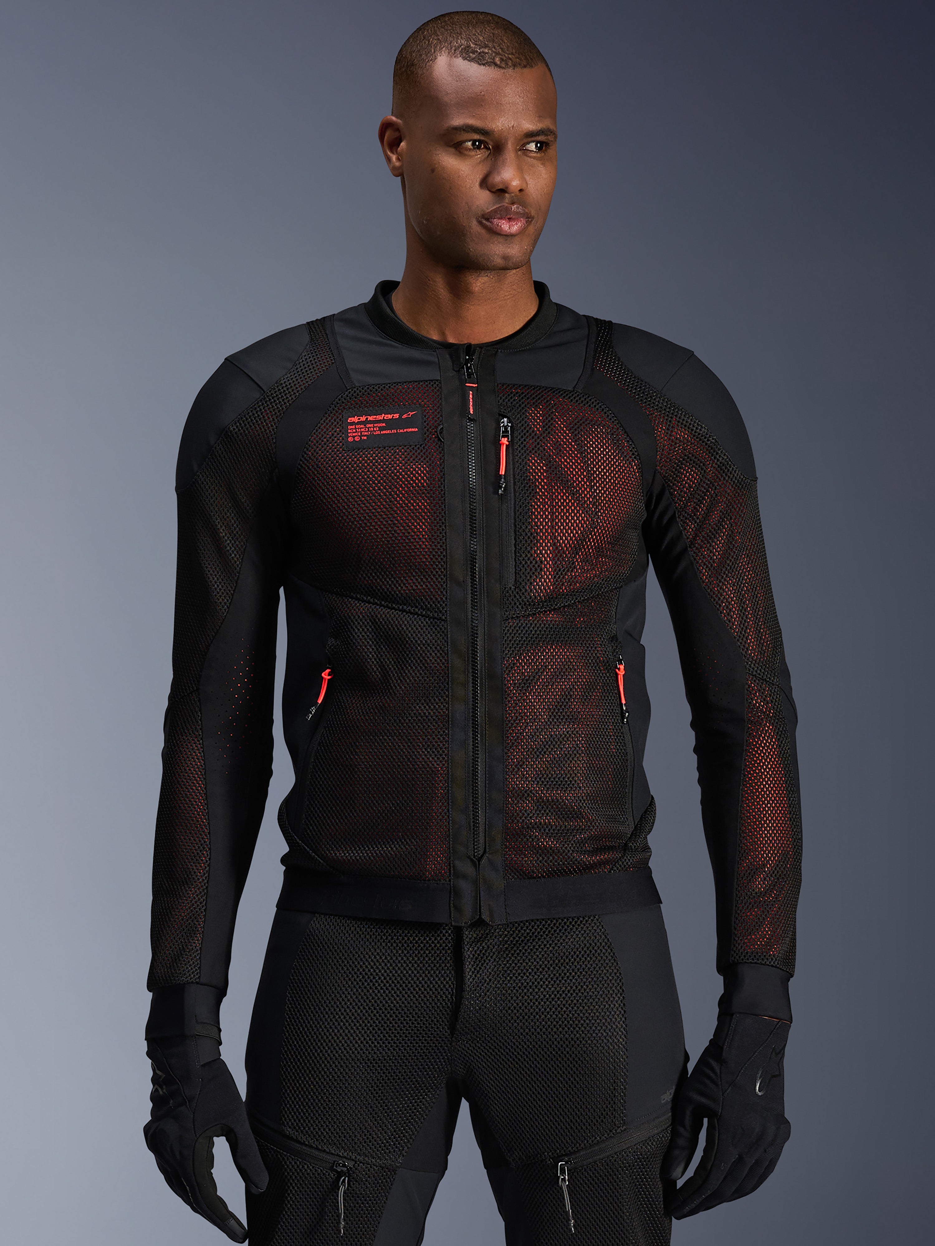Alpinestars Troop-Air Pro Jacket, casaco técnico blindado para motociclismo, Preto e Vermelho Fluo, com puxadores de fecho vermelhos e logótipo Alpinestars, painéis de malha respirável com fundo vermelho, usado com calças e luvas de motociclismo pretas a condizer