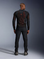 Casaco Alpinestars Troop-Air Pro em Preto e Vermelho Fluo, vista traseira no modelo, casaco de rede técnico com proteções e painéis respiráveis, logótipo vermelho na parte superior das costas, usado com calças pretas e sapatilhas, vestuário de motociclismo urbano