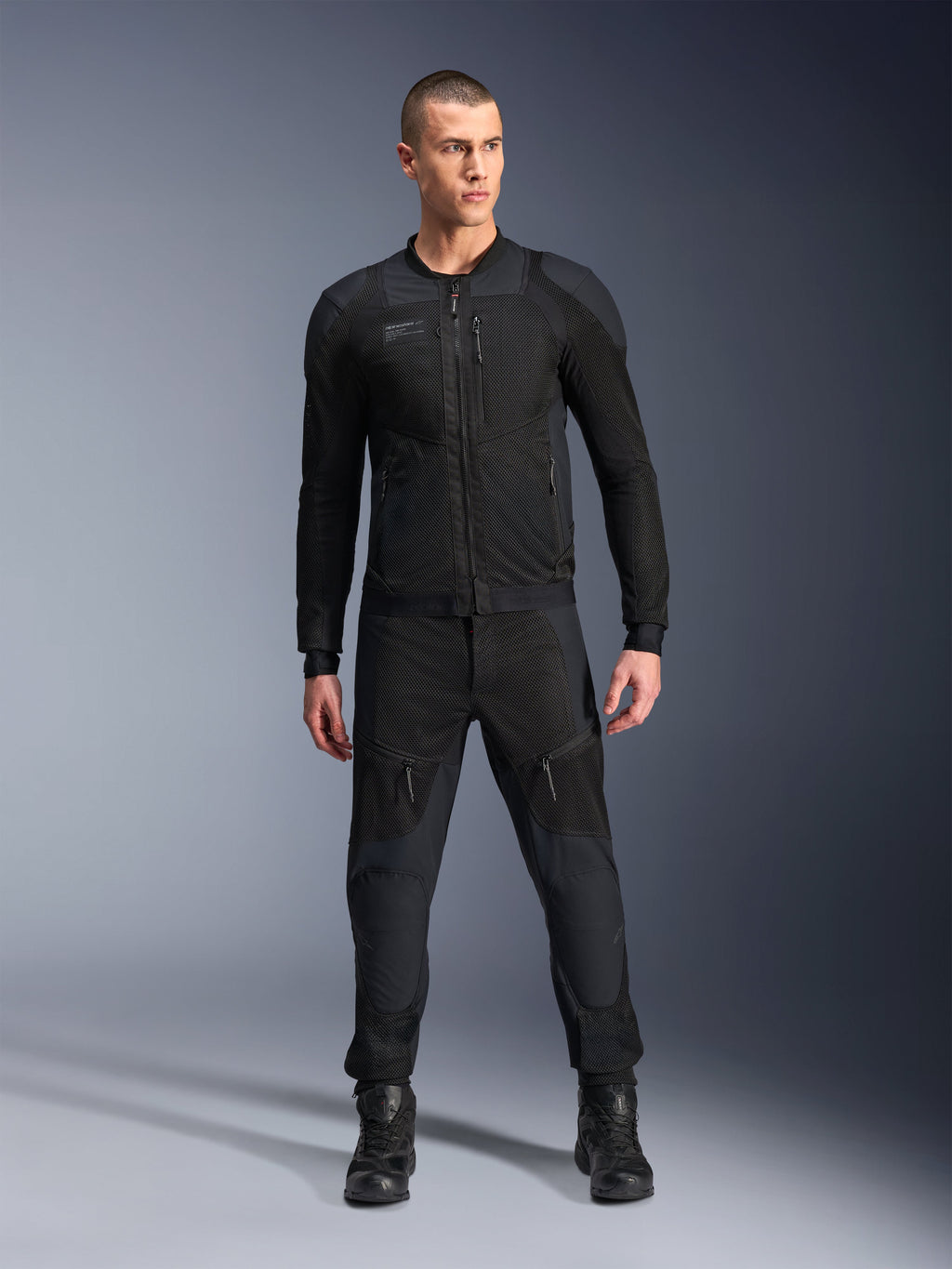Alpinestars Troop-Air Pro Jacket, casaco de motociclismo técnico blindado preto, com painéis de malha e fechos frontais, usado com calças pretas a condizer e botas de condução, equipamento urbano premium