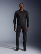 Modelo masculino a usar o Casaco Alpinestars Troop-Air em preto, casaco de motociclismo em malha leve, combinado com calças e botas de condução pretas a condizer, com uma construção técnica em malha 2D para um fluxo de ar superior.