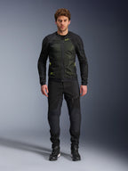 Modelo masculino a usar o Casaco Alpinestars Troop-Air em Preto Amarelo Fluo, com painéis de malha técnica e detalhes em amarelo vibrante, combinado com calças de motociclismo e calçado pretos, vestuário de motociclismo contemporâneo para tempo quente