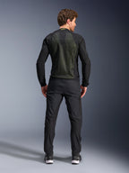 Alpinestars Troop-Air Jacket, Preto Amarelo Fluo, vista traseira num modelo, com um grande painel traseiro em malha técnica 2D para ventilação, casaco técnico de motociclismo usado com calças e botas pretas, estilo urbano de motociclismo
