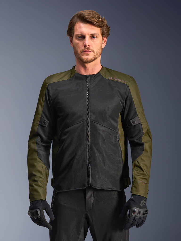 Alpinestars C-1 Air Jacket, casaco de motociclismo para homem, cáqui e preto, com grandes painéis de malha técnica para o máximo fluxo de ar, usado por um modelo com calças de condução e luvas pretas, design urbano contemporâneo para deslocações urbanas