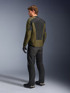 Modelo masculino a usar o Casaco Alpinestars C-1 Air em Khaki, casaco de motociclismo urbano, vista traseira destacando os grandes painéis de malha preta nas costas, combinado com calças técnicas de condução e luvas pretas, equipamento de motociclismo contemporâneo para tempo quente