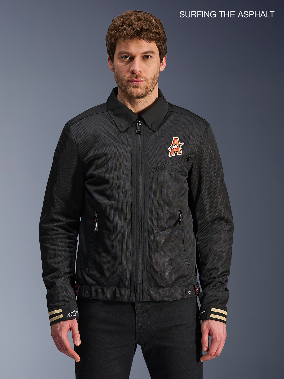 Alpinestars Jaqueta Ignite Air, casaco de moto urbano para homem em preto, vista frontal num modelo com gola de camisa tradicional, gráficos inspirados em clubes no peito e construção certificada CE.