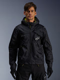 Alpinestars Mogress Air Jacket, urban motorcycle jacket, Black with Lime Punch accents, worn by a model with black riding pants and gloves, utility-inspired design with a hood and white star logo on the chest, lightweight textile gear for street riding