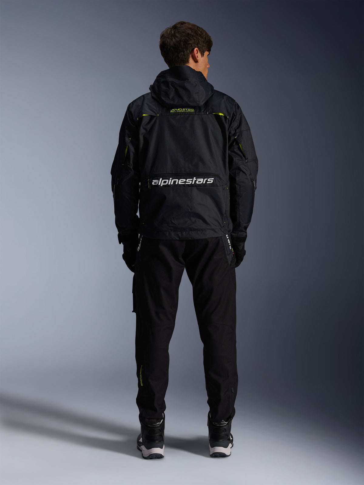 Alpinestars Mogress Air, casaco de moto urbano têxtil, preto e verde lima, vista traseira com logótipo branco.