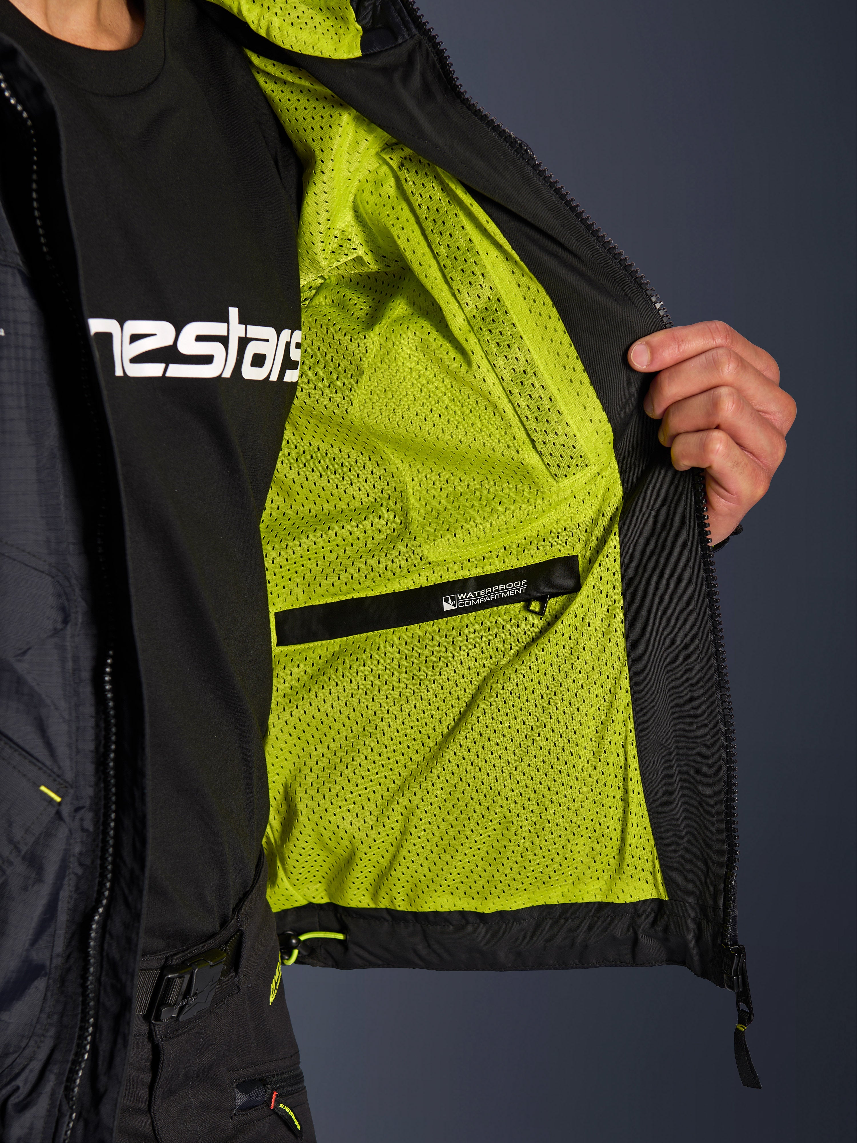 Alpinestars Mogress Air Jacket, interior detail featuring vibrant lime punch mesh lining and a black waterproof inner compartment, functional urban motorcycle apparel design.
