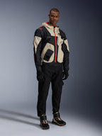 Homem com equipamento completo de motociclismo urbano Alpinestars, incluindo sapatos Speedstreet em Black Almond Hot Orange e casaco Mogress Air em preto e creme, calças e luvas pretas coordenadas, conjunto de proteção inspirado em streetwear para condução urbana