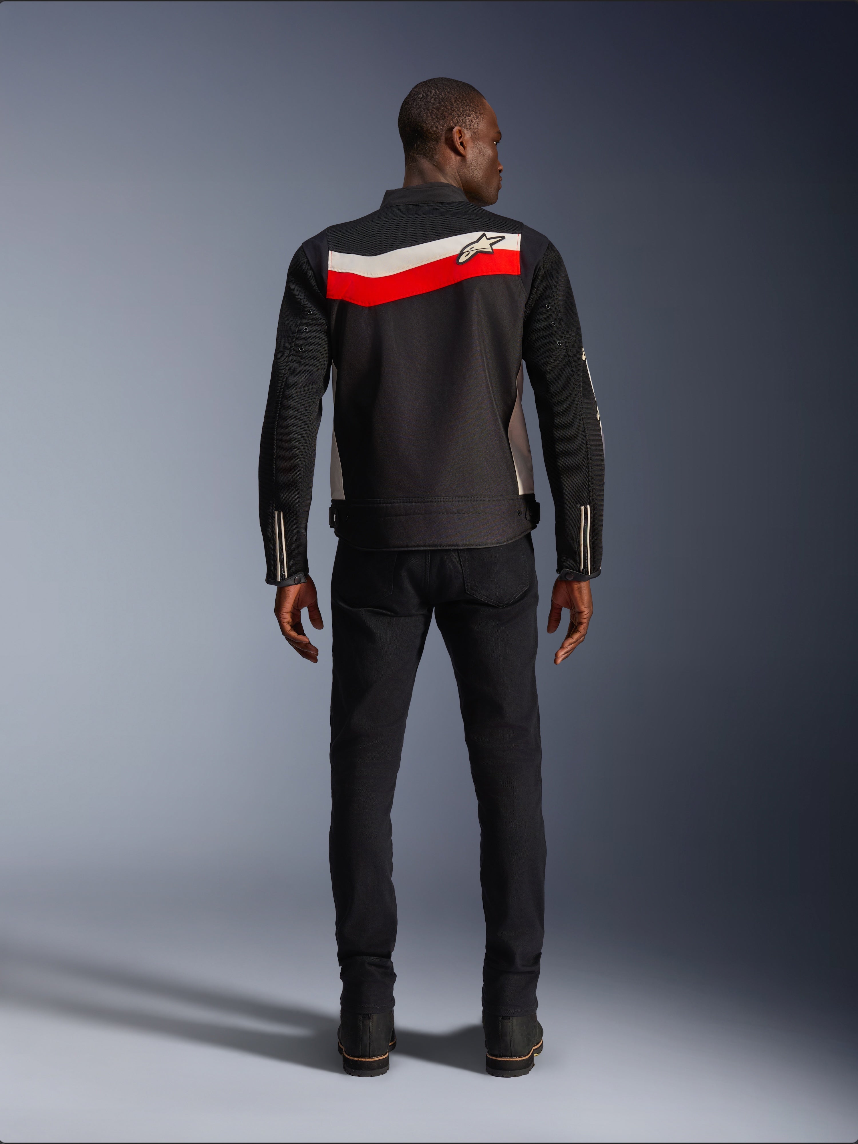 Alpinestars T-Dyno Air Jacket, Men's Textile Motorcycle Jacket, Rear view, Black with Bright Red and Ecru horizontal stripes across the back, Alpinestars logo on the yoke, worn with black pants and boots, breathable 3D mesh construction