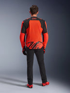 Back view of the MM93 T-SPS Air V2 Jacket, Red Fluo and Black, textile motorcycle jacket with large mesh panels on the back for ventilation, worn with black pants and red footwear, featuring Marc Marquez 93 branding